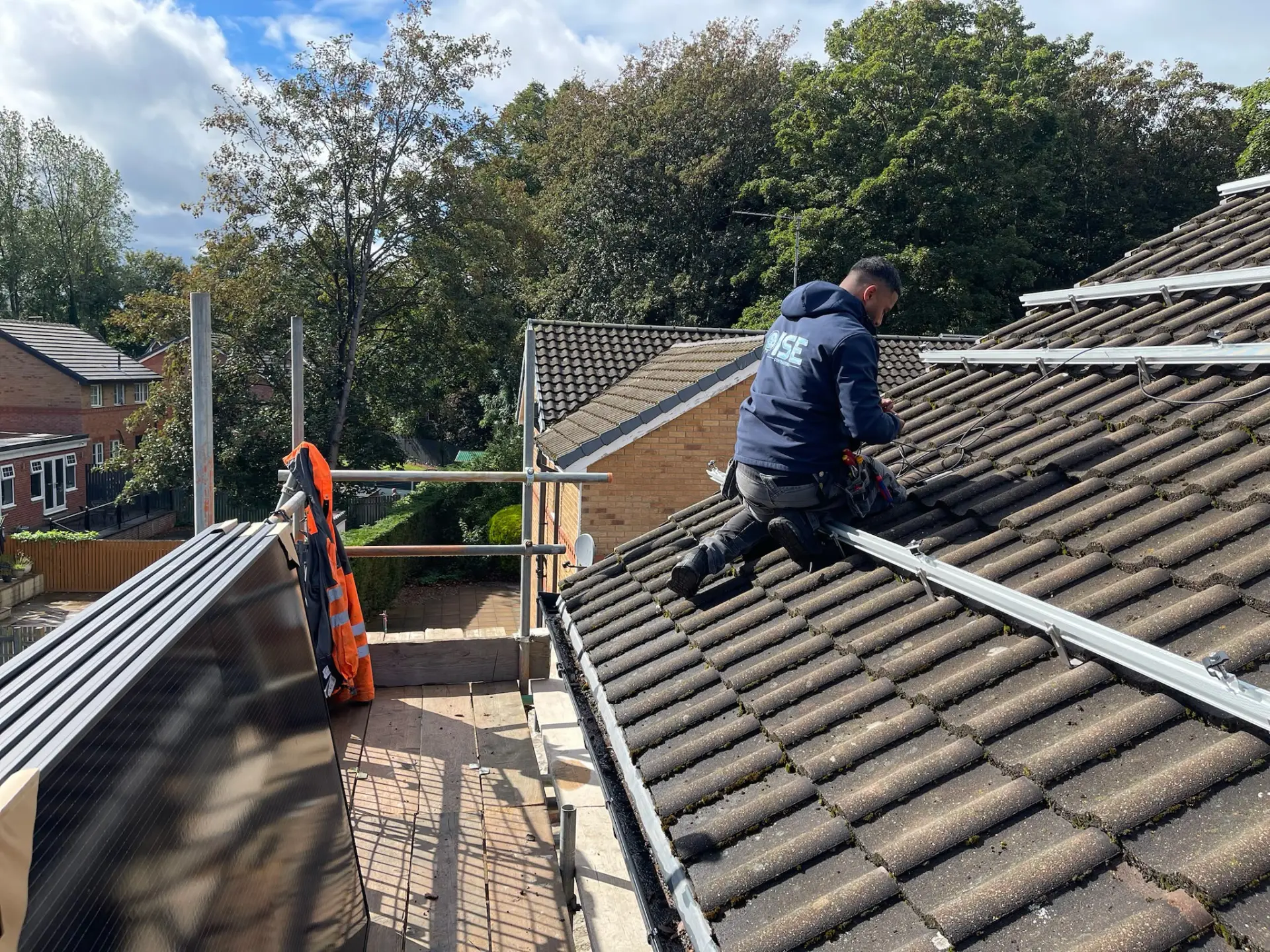 Nassau Electric League engineer installing solar panel rails on a home roof